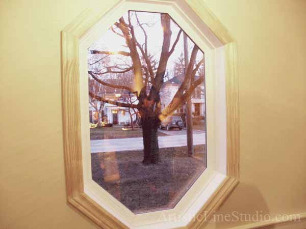 Stained and leaded glass octagon window with globes and beveled glass for the foyer of a private recidence