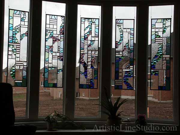 Abstract stained, beveled and leaded glass window panels set with nuggets and bevelled glass for a family room adding privacy and beauty