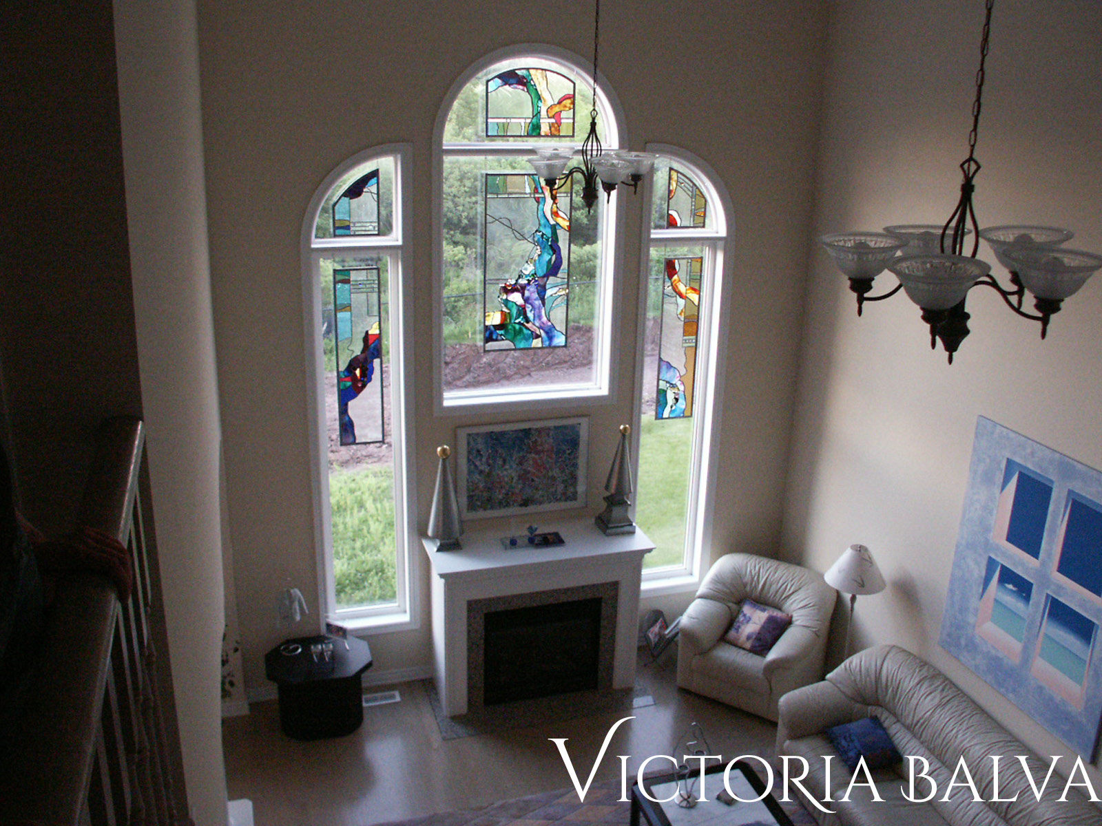 Stained and leaded glass suspended panels for a family room with fireplace a private recidence